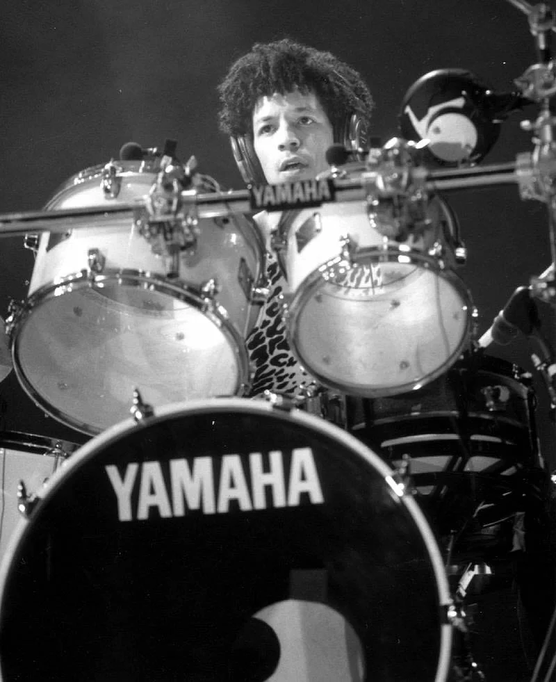 Black and white action shot of Zack playing a Yamaha drumset.