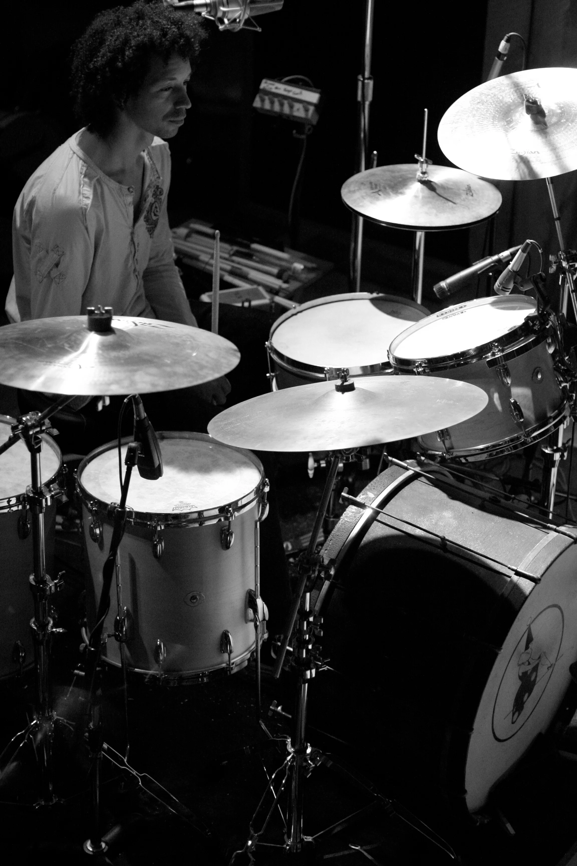 Black and white action shot of Zack sitting at a drumset, looking off into the distance.
